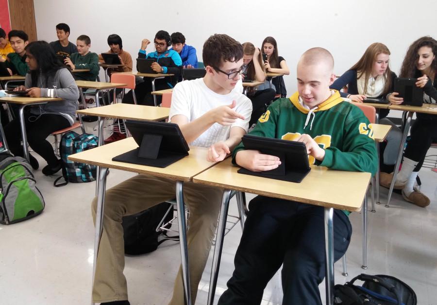 THE DIGITAL AGE: Freshmen Kevin Clauson and Michael Clausen benefit to the fullest extent from their iPads as they study for an upcoming AP Human Geography test. Several years ago, the class was entirely pen and paper; now, most classwork is online.
