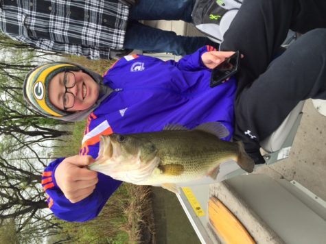 NICE CATCH: Freshman Alex Pillath holds up a fish he caught at practice on Busse Lake on May 1 preparing for sectionals. The team has the home advantage at sectionals which take place today in Busse Woods. State will take place at Carlyle Lake in Carlyle May 20-21.