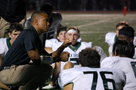 Head football coach Miles Osei speaks to his Elk Grove players during an away game at Buffalo Grove High School. The Grenadiers are 2-4 after winning a home game against Maine East, but dropping two in a row to Hersey and Buffalo Grove.