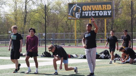 Head boys track coach Miles Osei raises a hand during a practice in April. Osei is leaving Elk Grove to be the head football coach at Kankakee High School.