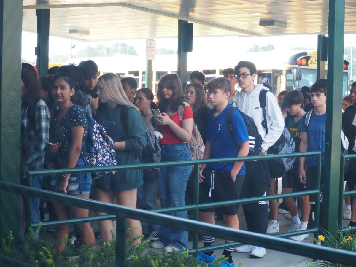 Elk Grove students wait outside as they scan into class in August. New rules about tardiness have taken effect at Elk Grove this fall. 